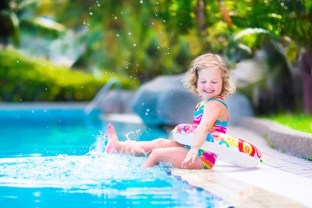 Adorable Little girl with curly hair playing with water