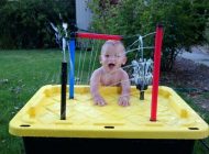 Little kid playing in a water splashes