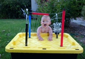 Little kid playing in a water splashes