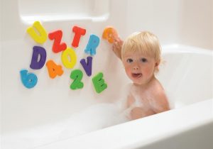 A kid playing with alphabets while bathing
