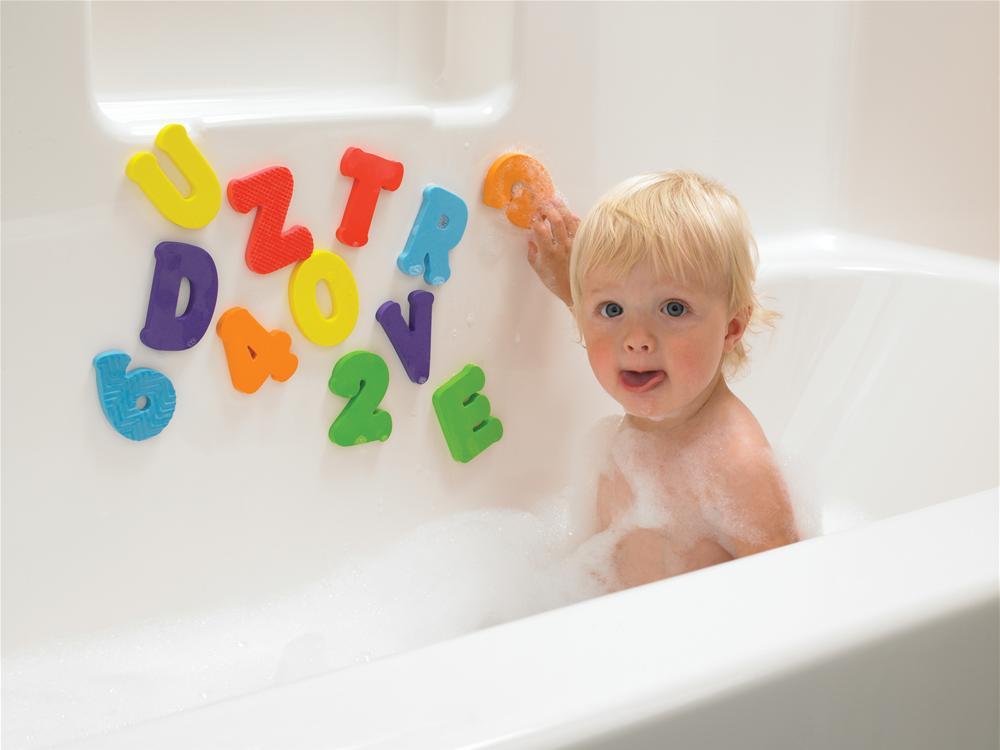 A kid playing with alphabets while bathing