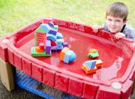 A Boy sitting and playing with pool toy