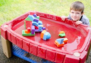 A Boy sitting and playing with pool toy