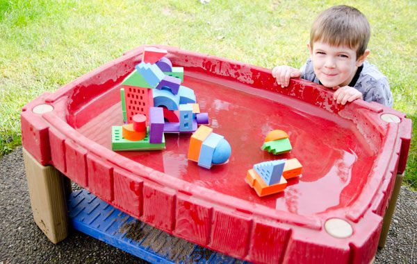 A Boy sitting and playing with pool toy